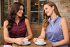 Two women enjoying a cup of coffee after playing a round of golf