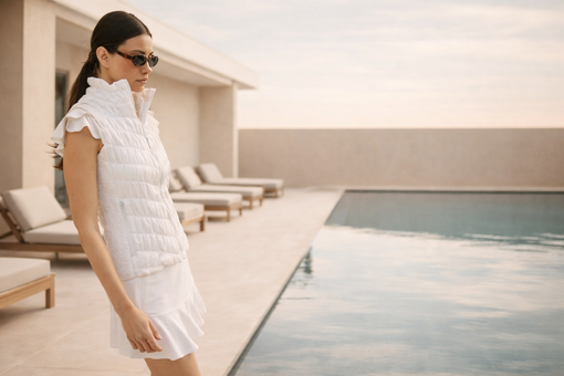 Woman wearing golf clothes with confident elegance by the pool