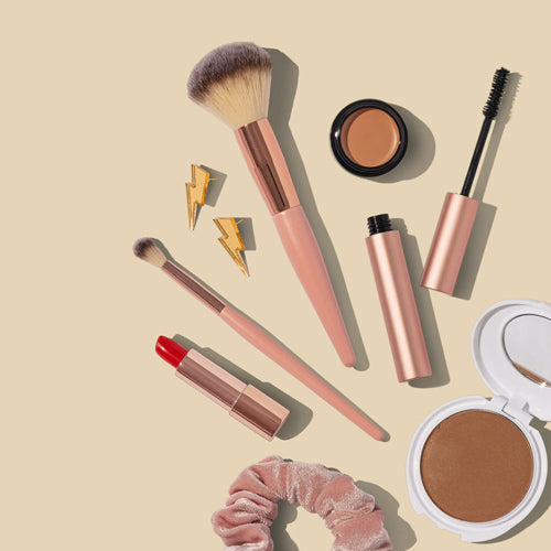 several makeup brushes and lightning bolt earrings