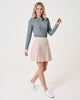 Fairway Skort in stone, 18 inches, pleats and zip pockets, hem moving as she steps.