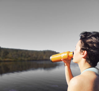  woman drinking bottle at lake